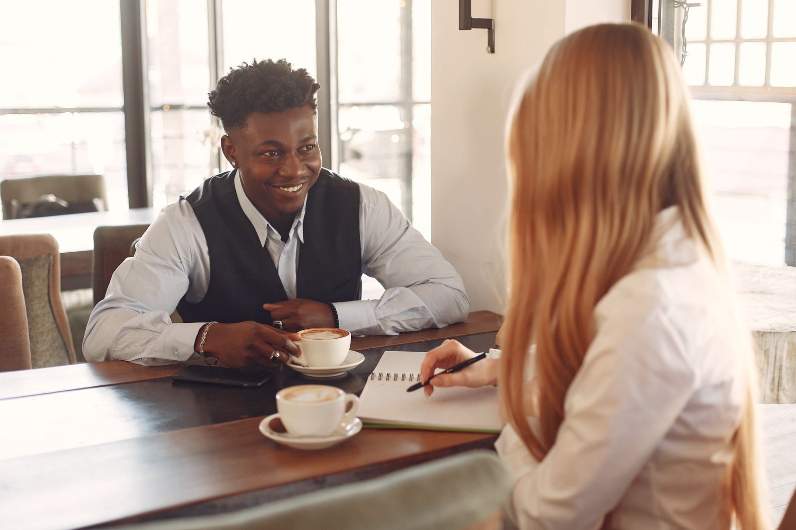 Two people talking over coffee at a café table
