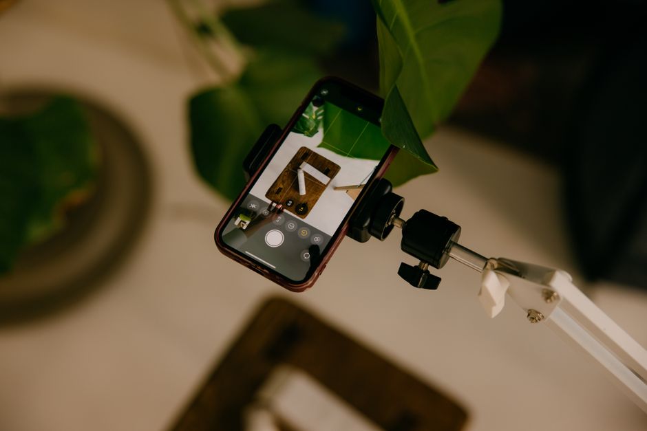 A phone on a small tripod filming a plate of food on a café table