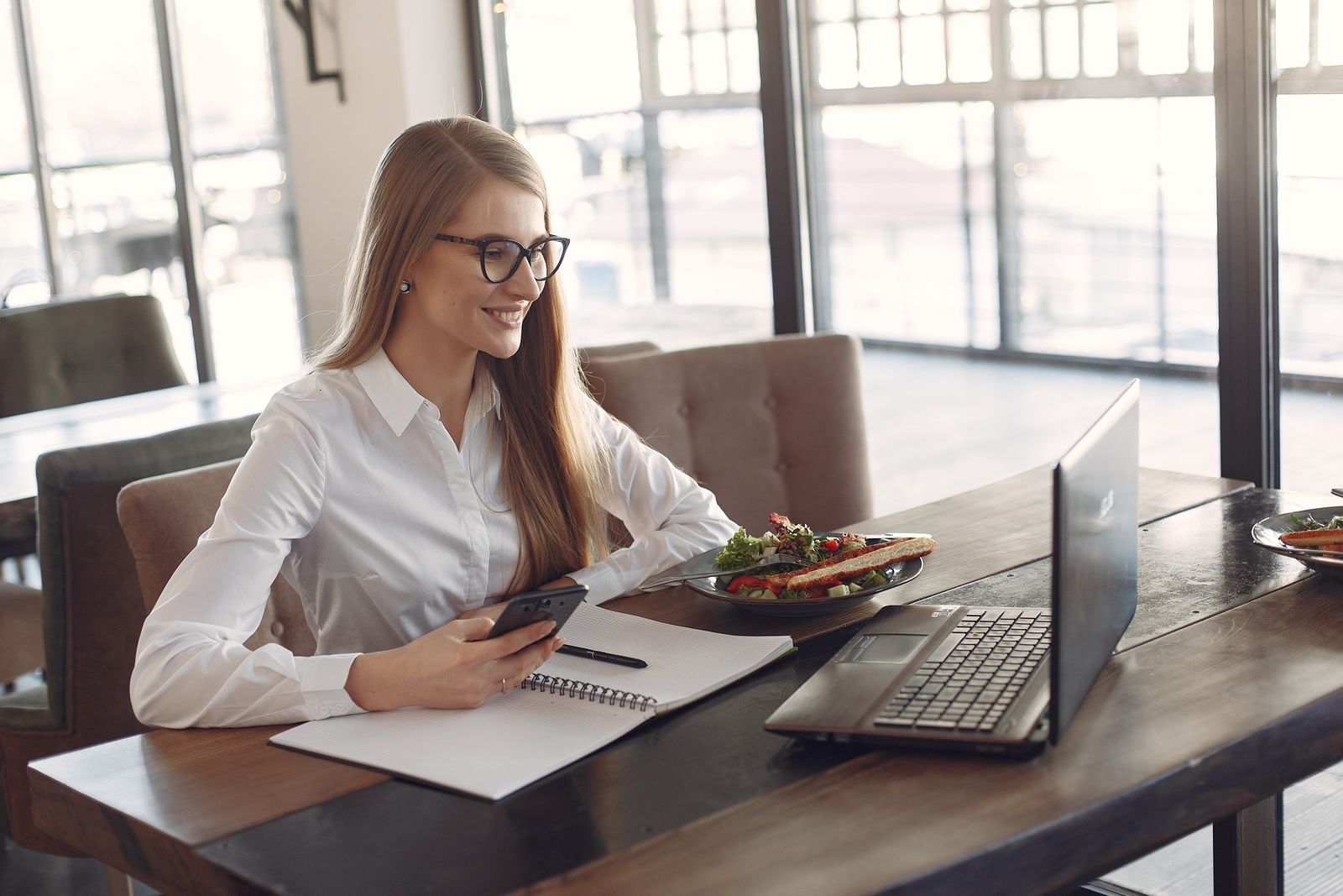 A small business owner using a smartphone at a café table