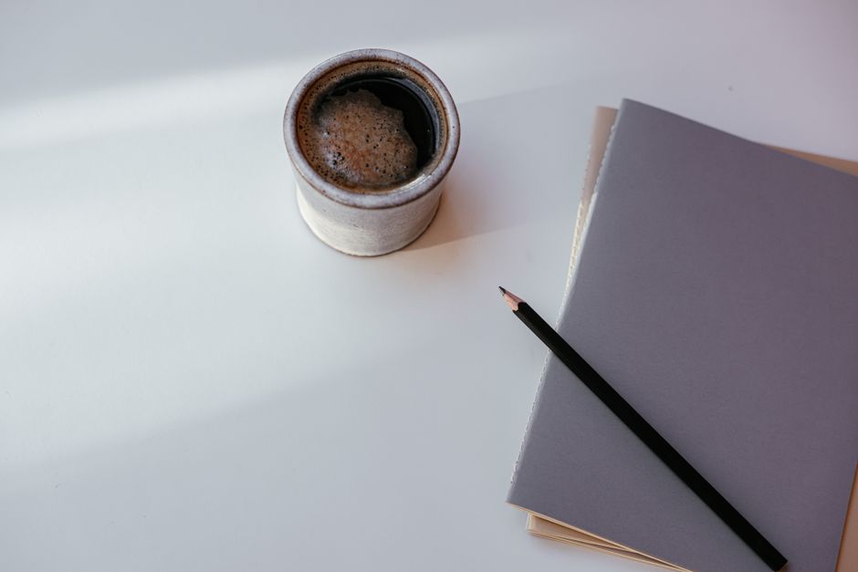 A notebook and a coffee on a café table in the evening